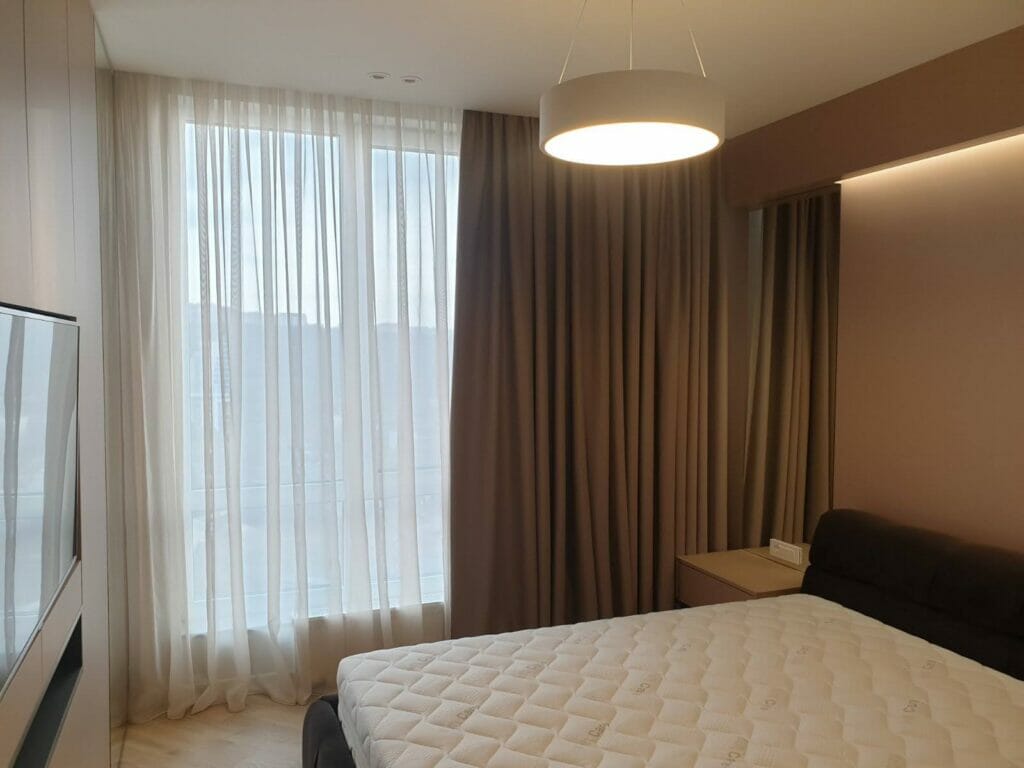 A bedroom with a bed and a tv.